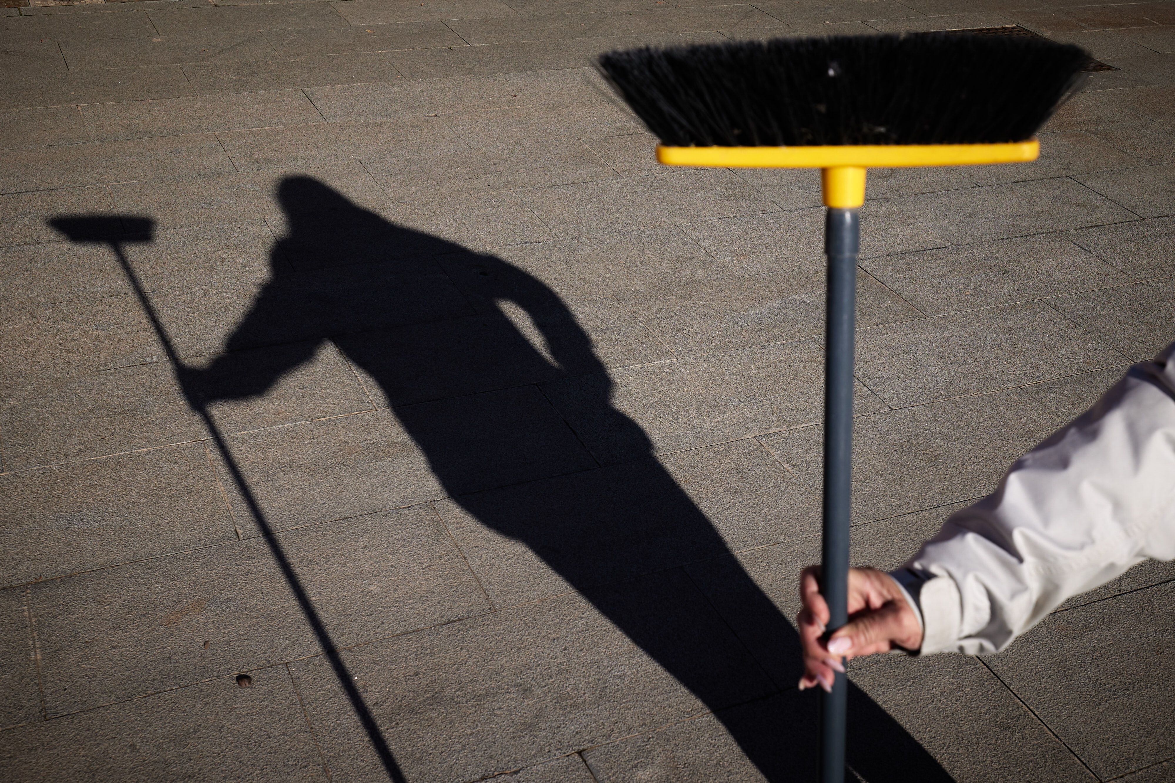 La sombra de Cristina con el cepillo con el que trabaja, el jueves en Granada.
