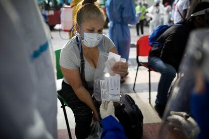 Una paciente asintomática recibe de una doctora una bolsa con cloroquina, azitromicina y dexametasona el 25 de agosto en Caracas.