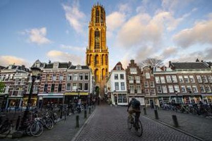 Un ciclista pasea por una calle atestada de bicicletas en Utrecht (Países Bajos).