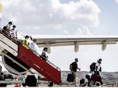 Viajeros descienden de la escalerilla de un avión de Iberia.