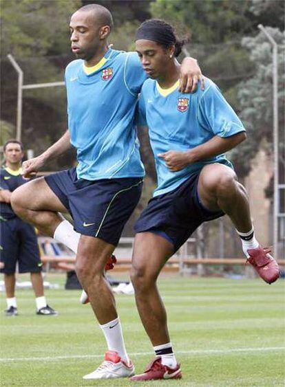 Los jugadores del F.C Barcelona, el francés Thierry Henry  y el brasileño Ronaldinho , durante los ejercicios preparatorios en el primer entrenamiento que la plantilla azulgrana ha realizado esta mañana en las instalaciones del club