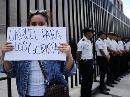 Una mujer muestra un cartel que pide cárcel para los golpistas a las puertas del ministerio público, este jueves en Ciudad de Guatemala.