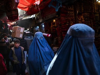 Dos mujeres con burka caminaban el domingo pasado por un mercado de alfombras en Kabul.