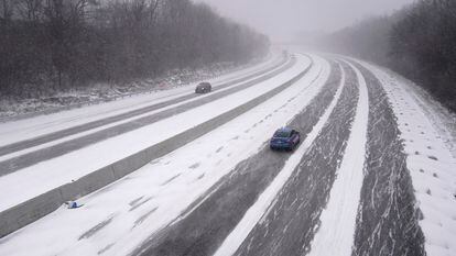 Dos coches avanzan sobre el hielo y la nieve en la interestatal 44, en el Estado de Misuri, este viernes.