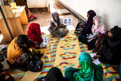 Una mujer imparte a un grupo de madres un breve curso de cómo alimentar bien a los niños, a la entrada del hospital Trocaire, en Dolow.