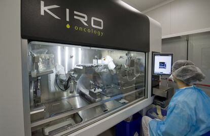 Una tècnica de farmàcia supervisa el procés de manipulació de fàrmacs que fa el robot.