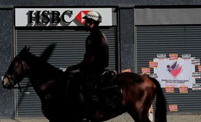 Un policía patrulla ante una sucursal del HSBC en Río de Janeiro.