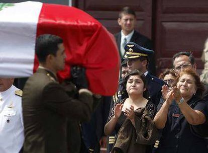 La madre y la hermana de un soldado peruano muerto en una emboscada de Sendero Luminoso lloran al paso del féretro.