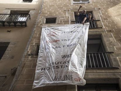 Unos vecinos desplegando una pancarta contra los pisos tur&iacute;sticos.