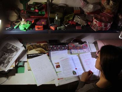 Una adolescente hace los deberes en su habitación.