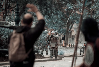 Un funcionario de Carabineros apunta con su pistola lanzagases a un grupo de manifestantes, durante una protesta en 2019.