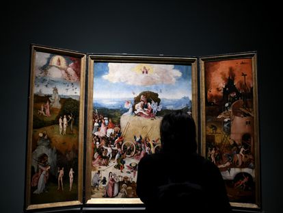 Una persona observa 'Tríptico del carro de heno', del Bosco, el dí­a de la reapertura de la sala donde permanecen las obras del artista en el Museo del Prado.