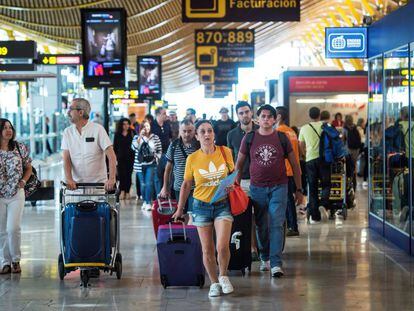 Viajeros en la terminal T4 del aeropuerto Madrid-Barajas Adolfo Su&aacute;rez.