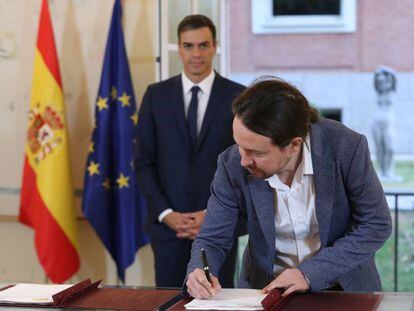 Iglesias firma el pacto en presencia de Sánchez, esta mañana en La Moncloa.