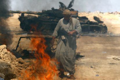 Un rebelde pasa ante un tanque del Ejército libio destruido por la OTAN en Ajdabiya.