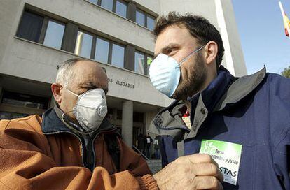 Dos activistas de Ecologistas en Acción ante las puerta de los Juzgados de plaza de Castilla.
