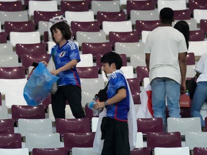 Aficionados japoneses recogen sus desperdicios en el estadio tras la victoria de su selección ante Alemania,  durante la Copa del Mundo organizada en Qatar, en noviembre de 2022.