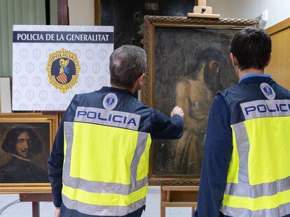 Dos agentes observan las pinturas atribuidas a Diego Velázquez y a Tiziano, pero que eran falsificaciones que habían salido al mercado.