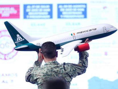 Un soldado del ejército acomoda una maqueta de un avión de Mexicana durante una conferencia en el Palacio Nacional, el 10 de agosto.