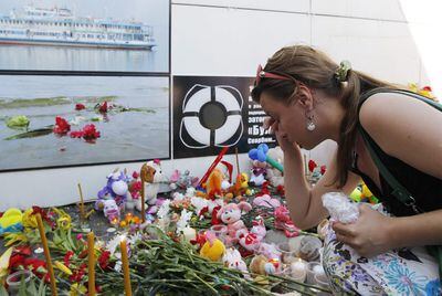 Una mujer, ante el improvisado altar en memoria de las víctimas del naufragio del <i>Bulgaria</i>, en Kazán.