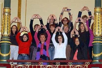 Representantes de las asociaciones de mujeres, que han sido invitadas al pleno del Congreso, forman con sus manos el triángulo símbolo del feminismo.