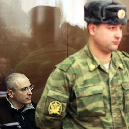 Mijaíl Jodorkovski, vigilado por un soldado en el tribunal de Moscú que le juzga.