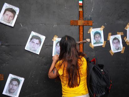 El 26 de septiembre de este año, una manifestante pega fotografías de los estudiantes desaparecidos de Ayotzinapa en una barricada frente a Palacio Nacional.