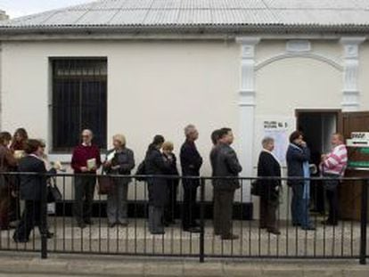 Gibraltareños hacen cola frente a un colegio para votar.