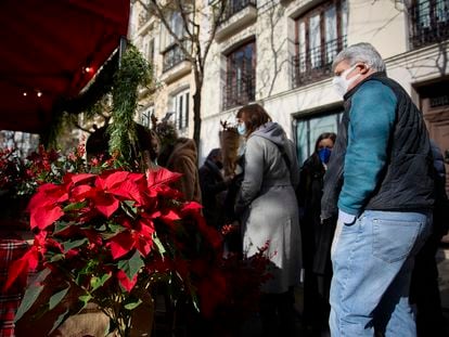 Varias personas acuden a los puestos en un mercado de flores en el barrio de Salamanca, el 18 de diciembre de 2021, en Madrid.