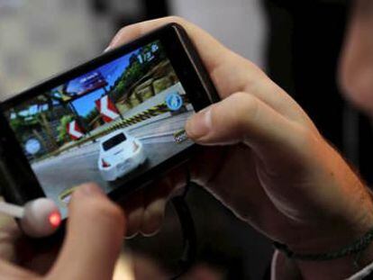 Una persona juega con el nuevo smartphone el L.G. Optimus 3D, un dispositivo en 3d que no necesita gafas, del grupo surcoreano LG.