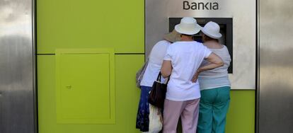"Yo es que sin mis gafas de cerca no veo nada". Tres mujeres sacan dinero de un cajero de bankia en Sevilla.