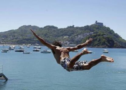 Un joven salta en el Real Club Náutico de San Sebastián, Guipúzcoa.