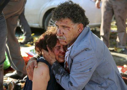 Un hombre reconforta a una mujer con la cara ensangrentada tras el atentado.