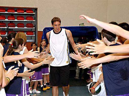 El jugador de baloncesto Pau Gasol saluda a niños en la localidad de Tres Cantos.