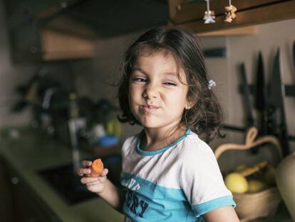 Una niña disfruta de una zanahoria. 
