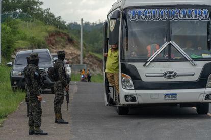 Miembros del Ejército de Honduras detienen un autobús de pasajeros con dirección a Tegucigalpa. 