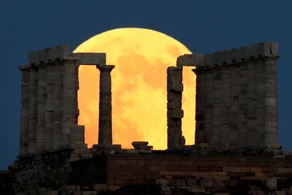 Una luna llena se levanta detrás del Templo de Poseidón antes del eclipse lunar en el Cabo Sounion, cerca de Atenas, Grecia, el 27 de julio de 2018.
