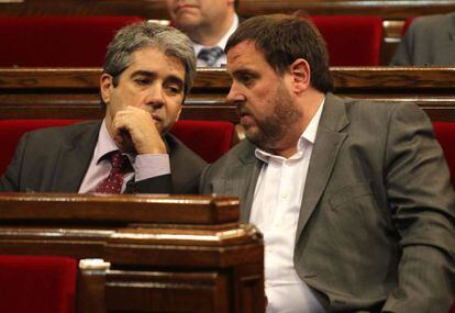 El lider de ERC, Oriol Junqueras (d), conversa con el consejero de Presidencia, Francesc Homs, durante el pleno del Parlament.