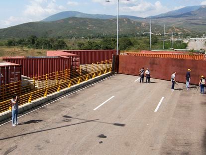 Funcionarios y periodistas inspeccionan los contenedores que bloquean el puente de Tienditas, entre Colombia y Venezuela.