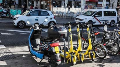 Patinetes, motos eléctricas y coches eléctricos de alquiler, en las calles de Madrid.
