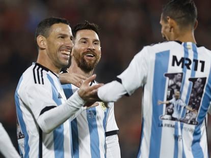 Lionel Messi (c) y Ángel di María (d) acompañan a Maxi Rodríguez (i), en su partido de despedida en Rosario (Argentina).