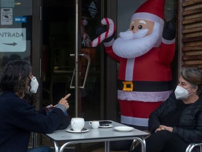 Dos personas conversan con la mascarilla puesta mientras se toman algo en la terraza de un bar, este miércoles en Ourense.