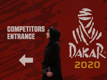 Una mujer pasa delante del logo del Rally Dakar en 2020.