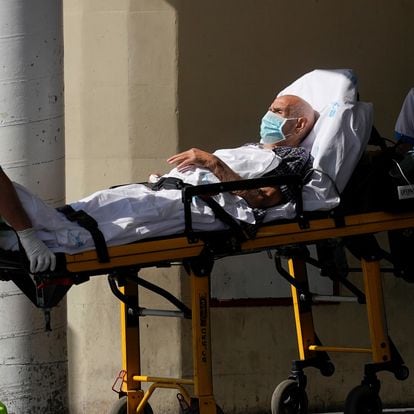 Healthcare workers wearing protective masks push a patient on a stretcher near the emergency unit at 12 de Octubre hospital, amid the outbreak of the coronavirus disease (COVID-19), in Madrid, Spain August 14, 2020. REUTERS/Juan Medina