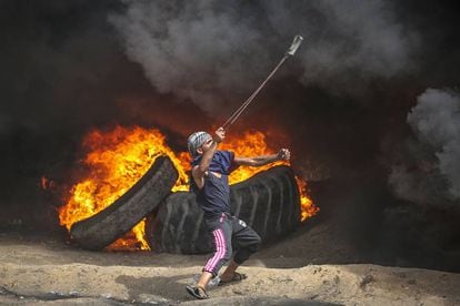 Palestinos lanzan piedras durante unas protestas cerca de la frontera con Israel en Gaza, este viernes.