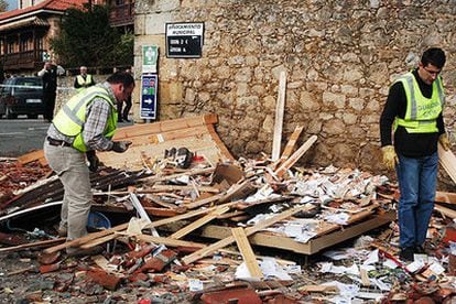 Dos guardias civiles inspeccionan el lugar donde estalló la bomba de ETA en Santillana del Mar.