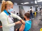MADRID, 24/08/2021.- Un hombre recibe la vacuna contra la covid en el punto de vacunación masivo instalado en el Wizink Center de Madrid, que vacuna a partir de este martes 24 de agosto las 24 horas del día sin cita previa a los madrileños que no hayan recibido aún ninguna dosis de la vacuna contra la covid-19, después de hacerlo desde el 13 de agosto en horario nocturno. EFE/Chema Moya
