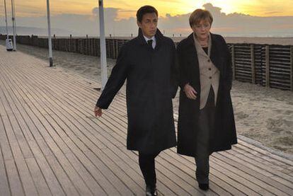 Sarkozy y Merkel pasean por la playa de Deauville, en el norte de Francia, el pasado 18 de octubre.