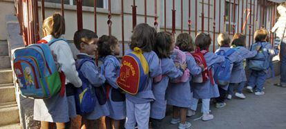 Niños haciendo cola a la puerta del colegio