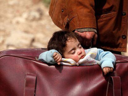 Un niño duerme dentro de un bolso en Beit Sawa, en el este de Guta, en Siria. 